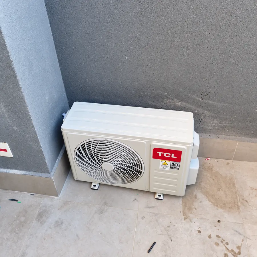 Condensadora de ar-condicionado instalada no piso de uma área externa